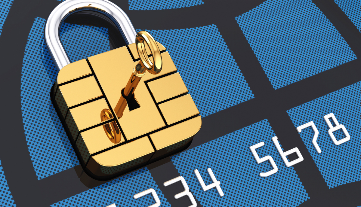 A gold padlock and key resting on the chip of a credit card