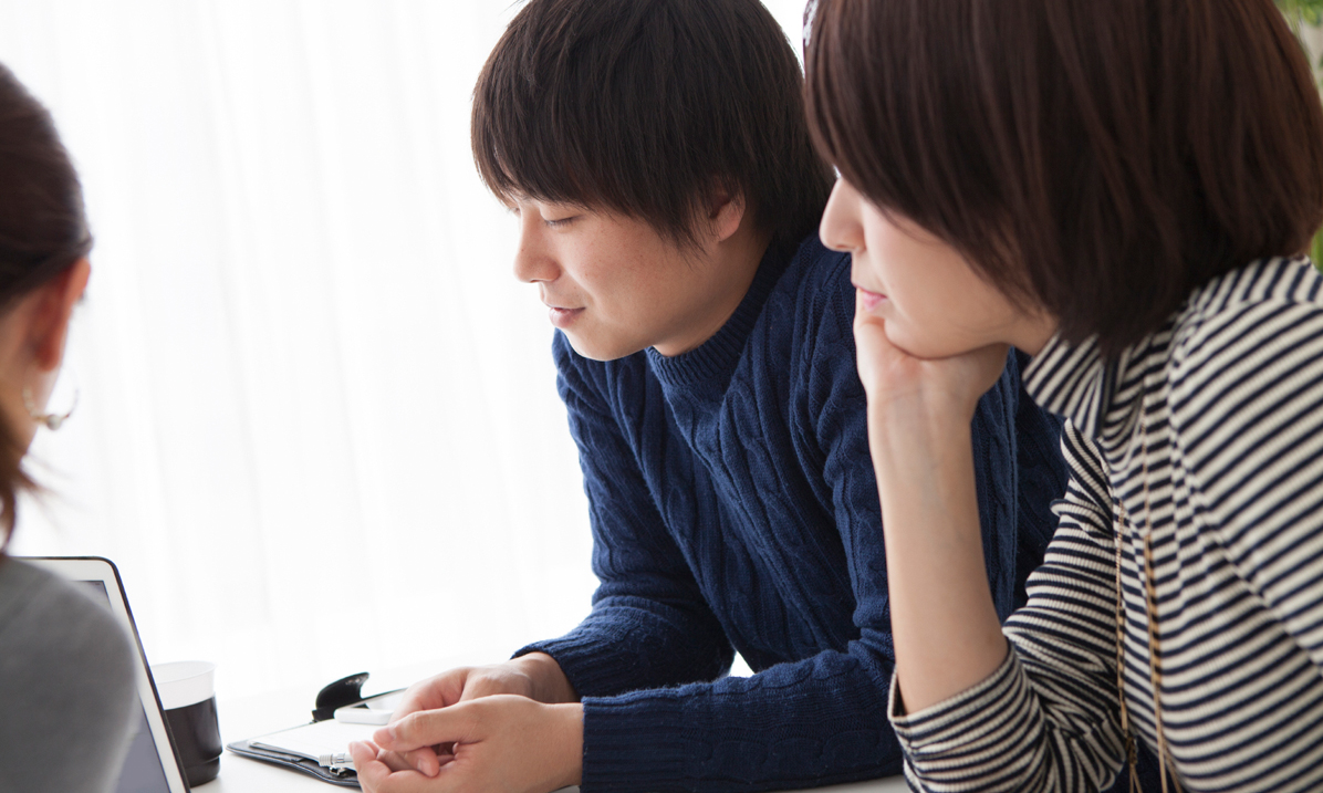 A young couple reviewing paperwork with a bank representative